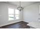 Bright dining area featuring hardwood floors, modern chandelier, and natural light from the large windows at 85 Windchime Ct, Fuquay Varina, NC 27526