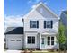 Charming two-story home with light gray siding, black shutters and a cute light blue front door at 85 Windchime Ct, Fuquay Varina, NC 27526