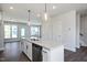 Open-concept kitchen featuring a large island with seating and stainless appliances at 85 Windchime Ct, Fuquay Varina, NC 27526