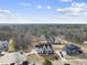 Stunning aerial view of a modern home with an expansive driveway and a well-manicured front yard and a wooded backdrop at 2908 Frances Marie Ln, Raleigh, NC 27603