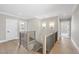 Bright hallway featuring hardwood floors, modern light fixtures, black metal railings, and white trim at 2908 Frances Marie Ln, Raleigh, NC 27603