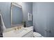 Charming powder room with blue walls, a stylish mirror, and a vessel sink at 2908 Frances Marie Ln, Raleigh, NC 27603