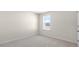 Well-lit room featuring a window with a view, neutral carpeting, and fresh paint at 420 Blue Aspen Dr, Fuquay Varina, NC 27526