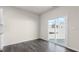 Empty room with sliding glass door, neutral walls, and wood-look flooring at 420 Blue Aspen Dr, Fuquay Varina, NC 27526