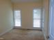 Bright bedroom with neutral carpeting and two large windows at 513 Port Dr, Henderson, NC 27537