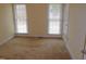 Bright bedroom with neutral carpeting and two large windows at 513 Port Dr, Henderson, NC 27537