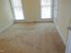 Bright bedroom with neutral carpeting and two large windows at 513 Port Dr, Henderson, NC 27537