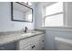 Stylish bathroom featuring a modern vanity with granite countertop, mirror, and toilet at 826 Carter Ave, Durham, NC 27703