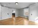 Sunlit bedroom boasts gleaming hardwood floors, complemented by light gray walls and two doors with white trim at 826 Carter Ave, Durham, NC 27703