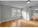 Simple bedroom with hardwood floors, gray walls, and two windows at 826 Carter Ave, Durham, NC 27703