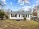 White house with gray roof, small front yard, and steps leading to the front door at 826 Carter Ave, Durham, NC 27703