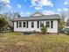White house with gray roof, small front yard, and steps leading to the front door at 826 Carter Ave, Durham, NC 27703