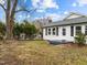 Quaint single-story home featuring black shutters, gray roof, and a cozy front porch at 826 Carter Ave, Durham, NC 27703