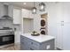 Kitchen island with white cabinets and stainless steel appliances, laundry closet at 110-A S Hyde Park Ave, Durham, NC 27703