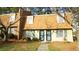 Front view of a yellow townhouse with blue doors and landscaping at 141 Jones Franklin Rd # G, Raleigh, NC 27606