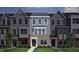 Close-up of townhome with a brick facade, gray siding, large windows, and a welcoming front door at 308 Chesapeak Commons St # 145, Garner, NC 27529