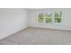 Sunlit bedroom features neutral carpet and three windows offering serene views at 43 Honeydew Way, Clayton, NC 27520