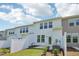 Townhouse exterior featuring a white fence, tidy lawn, and neutral siding with ample window lighting at 43 Honeydew Way, Clayton, NC 27520