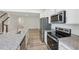Well-lit kitchen offers stainless steel appliances, granite countertops, and opens to the living area at 43 Honeydew Way, Clayton, NC 27520