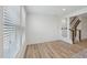 Bright living area with wood floors, staircase, and large window with blinds at 43 Honeydew Way, Clayton, NC 27520