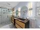 Bright bathroom featuring a glass shower, modern fixtures, and double vanity with mirrors at 5705 Katha Dr, Holly Springs, NC 27540