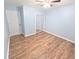 Bedroom featuring wood-look flooring, light blue walls and closet with decorative barn-style door at 5705 Katha Dr, Holly Springs, NC 27540