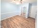 Bedroom featuring wood-look flooring, light blue walls and closet with decorative barn-style door at 5705 Katha Dr, Holly Springs, NC 27540
