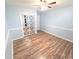 Well-lit bedroom showcasing hardwood floors, closet with mirrored doors, and neutral paint at 5705 Katha Dr, Holly Springs, NC 27540