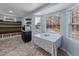 Bright breakfast nook with large windows, stylish shelving, and dining table with tablecloth at 5705 Katha Dr, Holly Springs, NC 27540