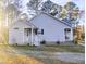 Single-story home with covered porches, blue shutters, and lush landscaping at 5705 Katha Dr, Holly Springs, NC 27540