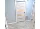 Hallway featuring grey wood-look flooring, light blue walls and white doors with glass panels at 5705 Katha Dr, Holly Springs, NC 27540