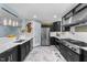 Modern kitchen features stainless steel appliances, black cabinets and a view to the living room at 5705 Katha Dr, Holly Springs, NC 27540