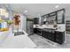 Modern kitchen features stainless steel appliances, wine rack, and black cabinets with white countertops at 5705 Katha Dr, Holly Springs, NC 27540
