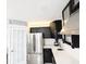 Galley-style kitchen with stainless steel appliances, white countertops, and decorative brick accents at 5705 Katha Dr, Holly Springs, NC 27540