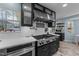 Kitchen with a stainless steel range, white countertops and backsplash, and black cabinets at 5705 Katha Dr, Holly Springs, NC 27540