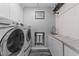 Laundry room features white washer and dryer, sink and cabinets with marble countertop at 5705 Katha Dr, Holly Springs, NC 27540