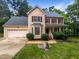 Charming two-story home with a well-manicured lawn, attached garage, and red shutters at 113 Crosswind Dr, Cary, NC 27513