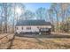 View of the home's backyard featuring a deck, white siding, and mature trees in a natural setting at 309 Monterey Ct, Benson, NC 27504