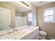 Bright bathroom featuring a dual sink vanity, large mirror, and window at 309 Monterey Ct, Benson, NC 27504