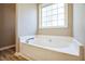 Bathroom featuring a soaking tub under a large window at 309 Monterey Ct, Benson, NC 27504