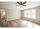 Bright bedroom featuring a ceiling fan, three windows and wood-look flooring at 309 Monterey Ct, Benson, NC 27504