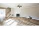 Spacious living room with fireplace, staircase, hardwood flooring, and neutral colored walls at 309 Monterey Ct, Benson, NC 27504