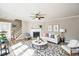 Staged living room with a fireplace, a ceiling fan, and a staircase to the second floor at 309 Monterey Ct, Benson, NC 27504