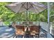 Outdoor dining space under a patterned umbrella on a deck, perfect for enjoying meals in the shade at 340 Andrews Store Rd, Pittsboro, NC 27312