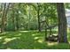 Grassy backyard with a wooden swing set surrounded by lush trees at 340 Andrews Store Rd, Pittsboro, NC 27312