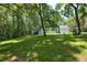 Expansive backyard with lush lawn, mature trees, and a charming swing set, ideal for outdoor activities at 340 Andrews Store Rd, Pittsboro, NC 27312