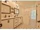 Bright bathroom with double vanities, modern fixtures, and a classic black and white tiled floor at 340 Andrews Store Rd, Pittsboro, NC 27312