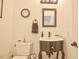 Cozy half bathroom features a round mirror, decorative clock, and gray vanity at 340 Andrews Store Rd, Pittsboro, NC 27312