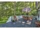 Relaxing deck area with stylish outdoor furniture and a shade umbrella at 340 Andrews Store Rd, Pittsboro, NC 27312