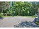 Long paved driveway with basketball hoop offers recreational space and ample parking surrounded by verdant foliage at 340 Andrews Store Rd, Pittsboro, NC 27312